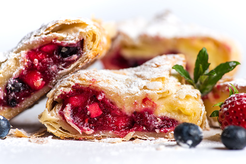 Homemade sweet pie with berry fruits covered with sugar powder closeup