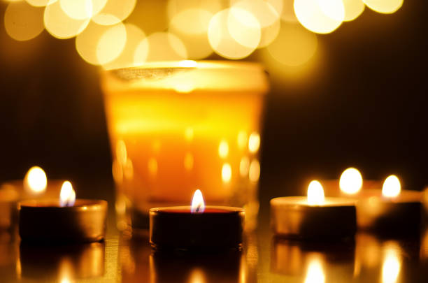 istock Burning candles with festive bokeh on a black background. Holiday and romantic concept. The concept of prayer and hope 1315022708