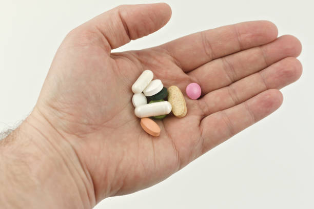 istock A handful of pills in a man's hand on a white background. 1315022827