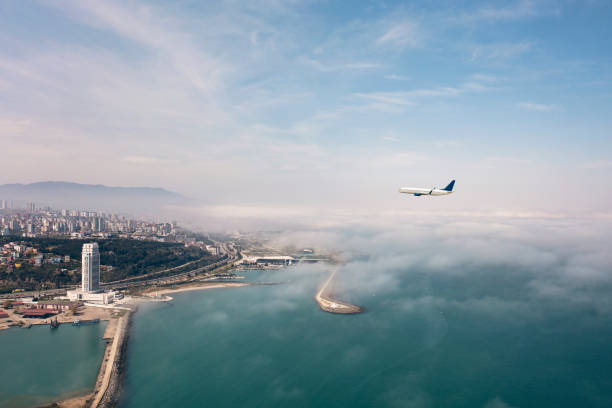 Commercial airplane flying over a coast city