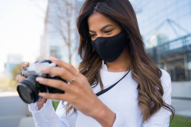 istock Young woman using camera outdoors. 1315029741