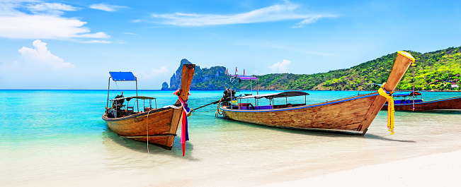 Panorama of thai traditional wooden longtail boat and beautiful sand beach at Koh Phi Phi island in Krabi province. Ao Nang, Thailand.