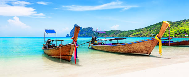 Thai traditional wooden longtail boats. Panorama of thai traditional wooden longtail boat and beautiful sand beach at Koh Phi Phi island in Krabi province. Ao Nang, Thailand. koh poda stock pictures, royalty-free photos & images