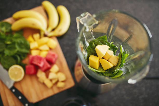 istock High angle shot of a blender filled with spinach and pineapple alongside freshly cut fruit on a kitchen counter 1315030440