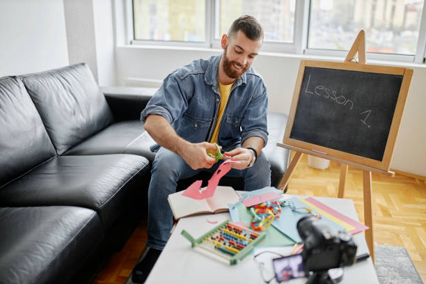 istock Creative male teacher filming tutorial at home during pandemic of coronavirus 1315030960