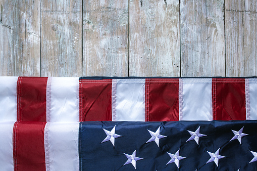Flag of USA on light grey wooden background.
Empty space provided for text placement for US celebrations such as: Memorial Day, Independence Day, etc.