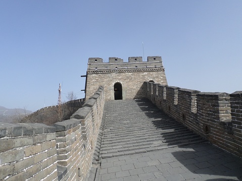 Panoramic vista across the verdant mountains, steep ridges and rocky summits that the watchtowers and battlements of the Great Wall of China climb for hundreds of kilometers over this picturesque Chinese  landscape.