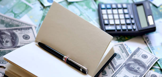 istock Notepad and pen, dollar and euro on the table. 1315038242