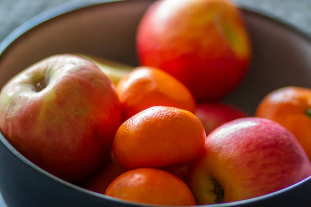 istock Bowl of fresh organic oranges and apples on a table 1315041108