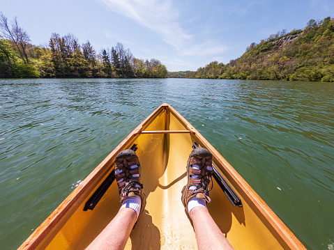 Caucasian man paddling in a pack canoe down the Monongahela river in Morgantown, West Virginia