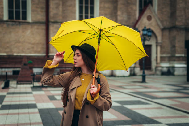 istock Woman holding a yellow umbrella during rain 1315042107