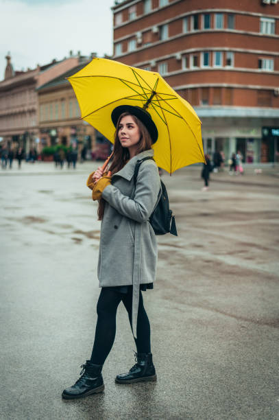 istock Woman holding a yellow umbrella during rain 1315042118