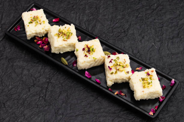 indian mithai hot kalakand burfi also known as alwar mawa qalaqand barfi, mishri mava or khoa milkcake is made of solidified milk meetha doodh khoya malai paneer. topped with crushed pista and elaichi - solidified imagens e fotografias de stock