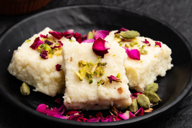 indian mithai hot kalakand burfi also known as alwar mawa qalaqand barfi, mishri mava or khoa milkcake is made of solidified milk meetha doodh khoya malai paneer. topped with crushed pista and elaichi - solidified imagens e fotografias de stock