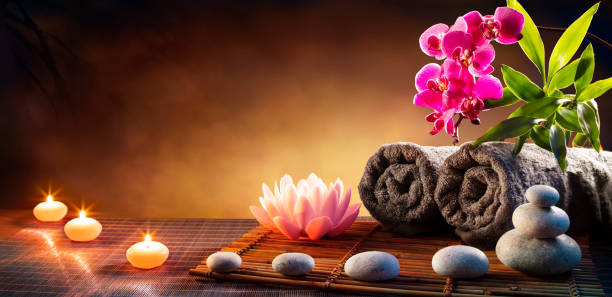 Spa Massage Treatment With Towels And Candles On Mat Health Stones Massage With Orchid hot stone massage stock pictures, royalty-free photos & images
