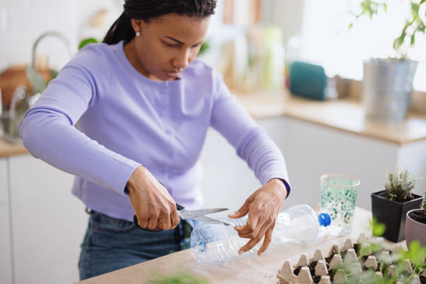 istock Woman using recycled plastic bottle to plant parsley 1315043672