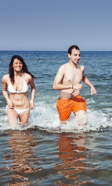 istock friends running on the beach together 1315045019