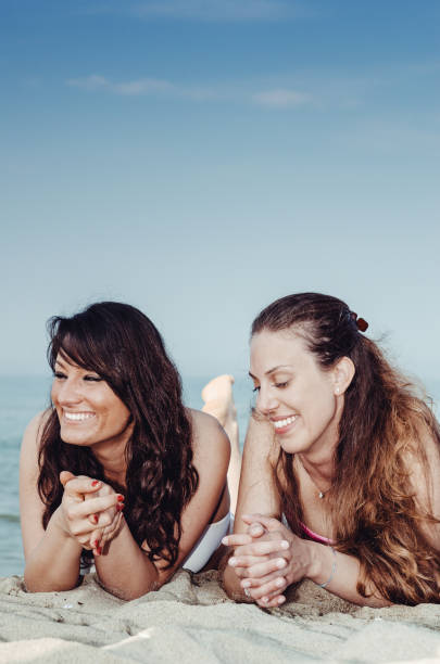 istock two friends sunbathing at the seaside 1315045937
