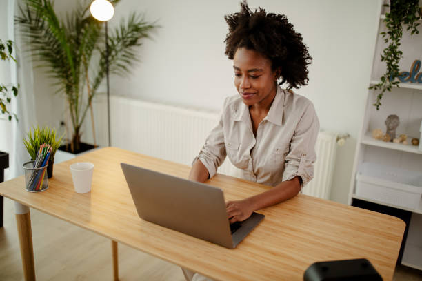 istock Young black smiling woman working at computer in an office. 1315046070