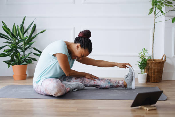 istock Woman stretching her legs while exercising at home 1315049552