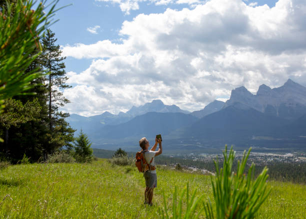 istock Hiker takes photo with digital tablet in mountain meadow 1315051532