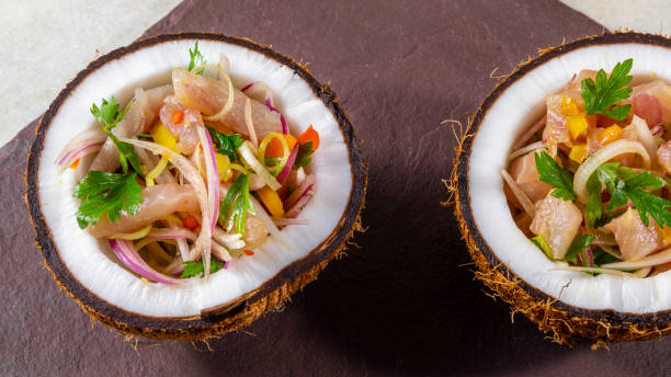 Ceviche dish - appetiser of fresh fish marinated in citrus with tropical fruits served in a Coconut Bowls Ceviche dish - appetiser of fresh fish marinated in citrus with tropical fruits served in a Coconut Bowls. appetiser stock pictures, royalty-free photos & images