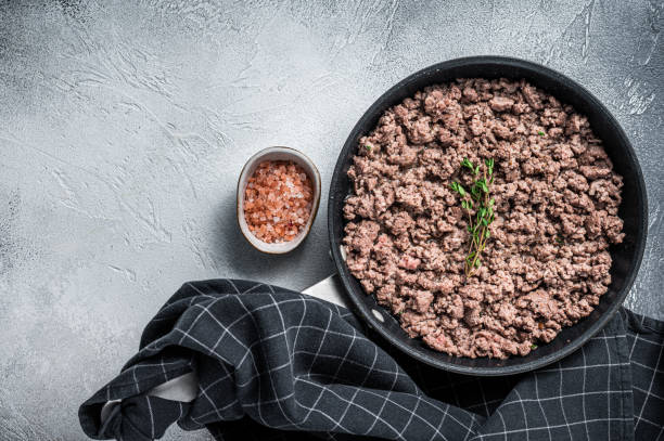 istock Fried mince beef and lamb meat in a pan with herbs. White background. Top view. Copy space 1315054639
