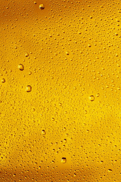 Close up view of cold drops on the glass of beer Close up view of cold drops on the glass of beer background. Texture of cooling alcohol drink with macro bubbles on the glass wall. Fizzing or floating up to top of surface. Golden colored. wet bottle stock pictures, royalty-free photos & images