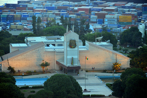 Conakry, Guinea: Sekhoutoureah Presidential Palace, official residence of the President of Guinea, 2eme Boulevard, named after president Ahmed Sékou Touré - Chinese built modern building, Guinean coat of arms and facade without windows, Tombo Island - harbor container park in the background.