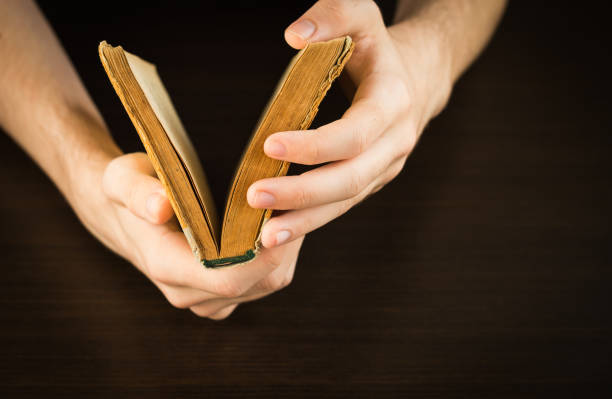 istock Hands of an young man holding a old book 1315059488