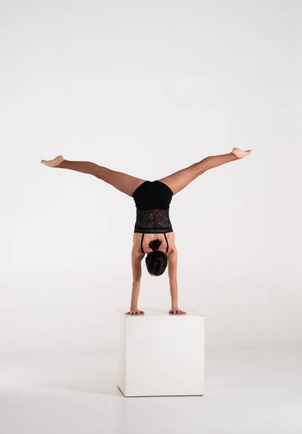 istock Good shaped man woman practicing handstand on white cube isolated on white background. Strength and motivation 1315060976