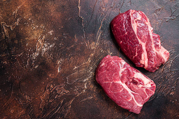 istock Raw Chuck eye roll beef steak on butcher table. Dark background. Top view. Copy space 1315062155