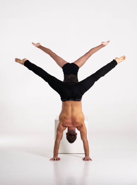 istock Good shaped man and woman practicing handstand exercise isolated on white background. Strength and motivation 1315062220