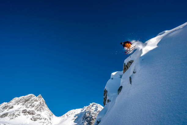 istock Skier jumps off cliff from mountain ridge 1315063691