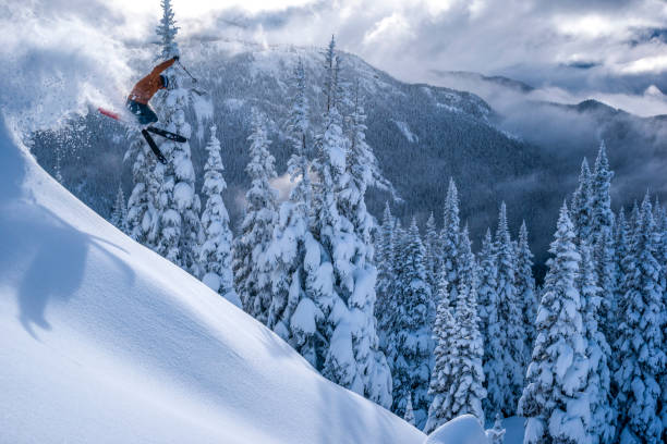 esquiador recebe ar em floresta coberta de neve em pó profundo - skiing winter sport powder snow athlete - fotografias e filmes do acervo