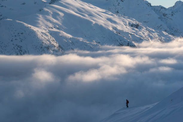 istock Ski mountaineer pauses on mountain ridge at sunrise 1315064716