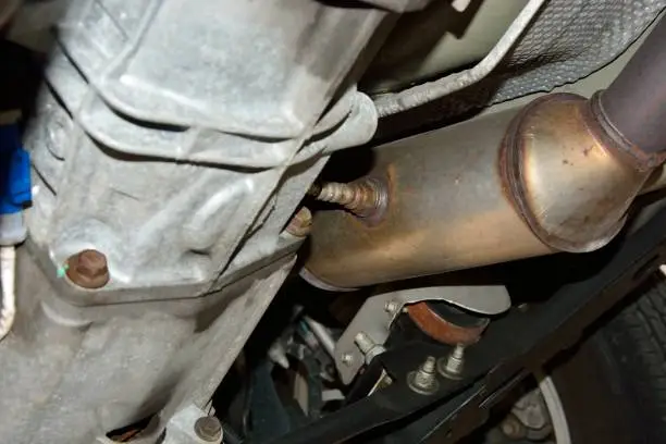 Selective focus on Oxygen Sensor mounted directly to a Catalytic Converter on the underside of a automobile. Catalytic Converters contain precious metals and are a target for theft.