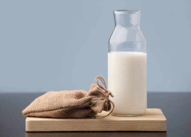 istock milk bottle with raffia sack on wood, blue background 1315070844