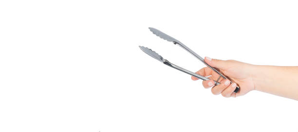 woman hand holding kitchen tongs woman hand holding kitchen tongs, isolated on white background, space for text serving tongs stock pictures, royalty-free photos & images