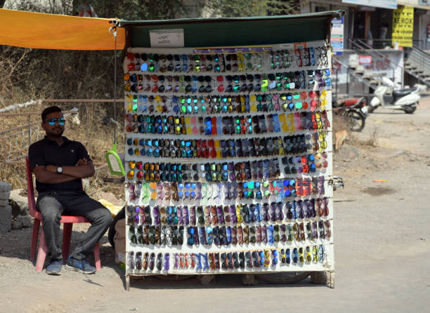Trader selling sunglasses by the roadside. Location: Nashik, Maharashtra, India. Date: February 17 2020