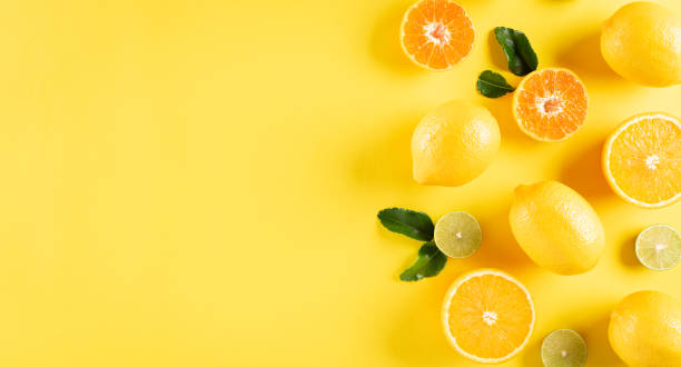 Summer composition made from oranges, lemon and green leaves on pastel yellow background. Fruit minimal concept. Flat lay, top view, copy space. Summer composition made from oranges, lemon and green leaves on pastel yellow background. Fruit minimal concept. Flat lay, top view, copy space. vitamin c stock pictures, royalty-free photos & images