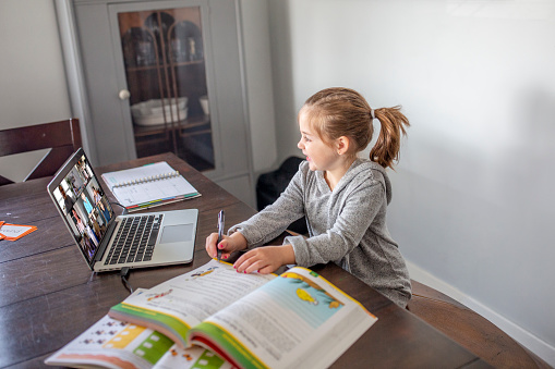 Young caucasian girl doing homeschool online during the Covid-19 pandemic.