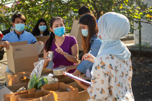 volontari della comunità per l'assistenza e la banca alimentare che lavorano durante la crisi covid-19 - charity and relief work foto e immagini stock