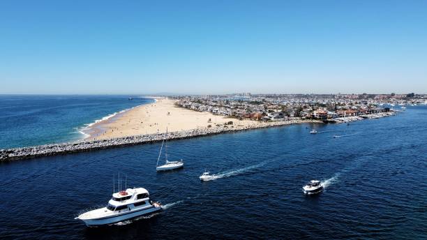 An aerial perspective of the Newport Peninsula with boats of various sizes leaving the harbor.
