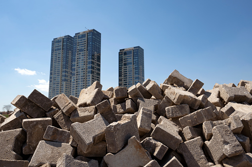 A grup of skyscrapers behind a pile of paving stones in Istanbul. Sky is blue and clear.