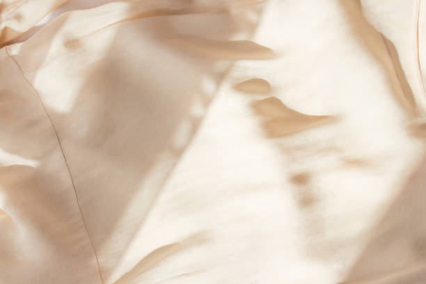 disposition plate abstraite de fond beige. fond minimaliste moderne avec texture de tissu froissé et plis en coton. vue supérieure pour la présentation - light and airy photos et images de collection