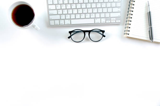 istock Modern white office desk table with keyboard computer, notebook, tree, glasses and cup of coffee. Top view with copy space, 1315113168