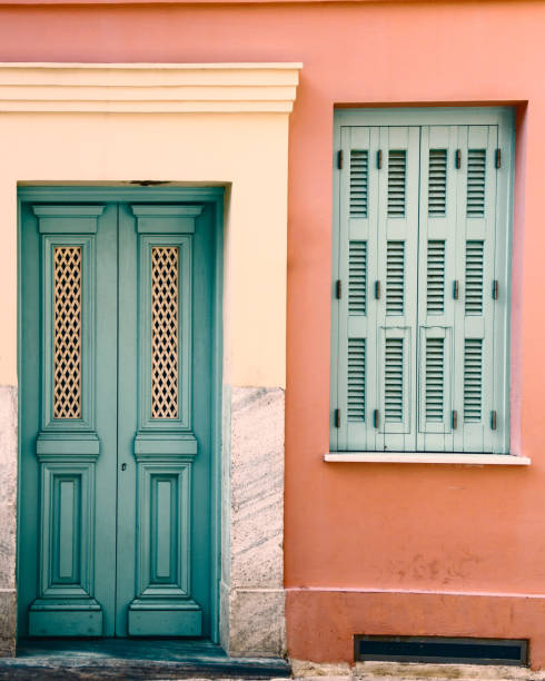 Pastel pink building with light blue door in Athens Greece