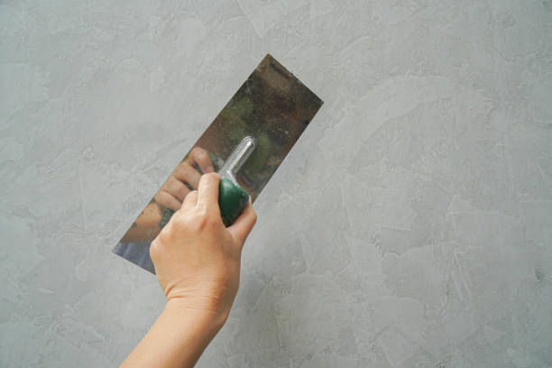 close up contractor hand use metal lute for loft cement house wall construction stock photo