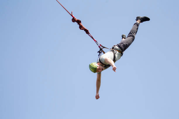 A man jumps from a bridge on a rope. Extreme sports. A man jumps from a bridge on a rope. Extreme sports. bungee jumping stock pictures, royalty-free photos & images